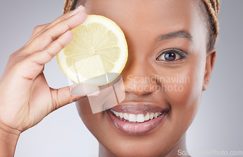 Image of Portrait, lemon and skincare with black woman in studio for natural, cosmetics or vitamin c. Nutrition, diet and detox with face of female model on grey background for citrus fruit and health product