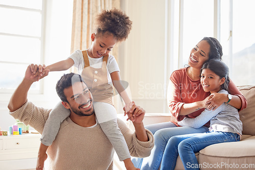 Image of Dad, mom and children in home, shoulders and happiness with playing games, hug or bonding in lounge. Father, mother and daughter with care, love and together with embrace, quality time or living room