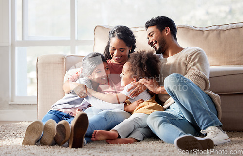 Image of Love, home and family on the floor, smile and bonding with affection, peaceful and loving together. Parents, mother or father with female children, kids or girl on the ground, lounge or weekend break