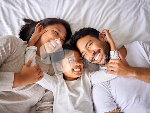 Image of Love, face and family in bed from above happy, smile and bonding in their home together. Hug, girl child and top view of parents with their daughter in a bedroom, relax and embracing indoors