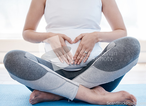 Image of Woman, pregnant and yoga with lotus, floor or relax for health, exercise and wellness for body, mind and peace. Girl, pregnancy pilates and zen meditation with mindfulness in gym, studio or house