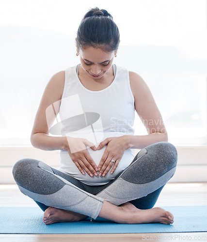 Image of Yoga, pregnancy and hands on stomach for woman, relax or health on floor for peace, future or mindset. Girl, pregnant pilates and zen meditation for mindfulness, hope or faith in gym, studio or house