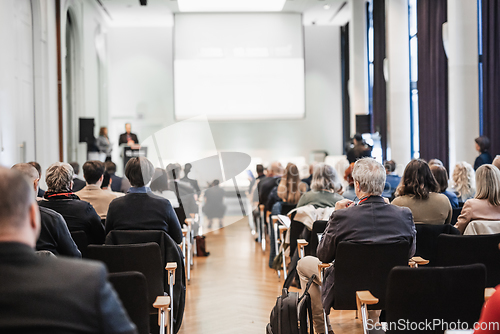 Image of Business team leader receiving award prize at best business project competition event. Business and entrepreneurship award ceremony theme. Focus on unrecognizable people in audience.