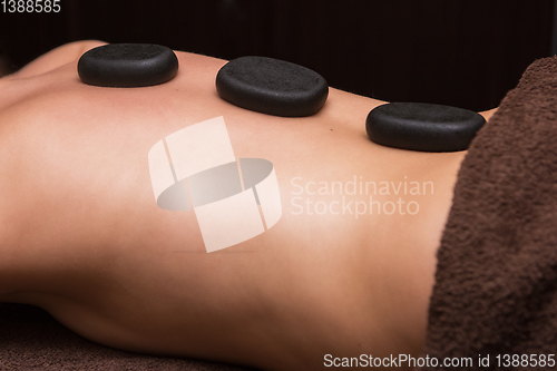 Image of therapy with hot stones in spa center