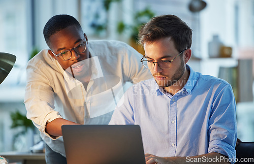 Image of Laptop, black man or manager training a worker with advice or research project in digital agency. Night, leadership or boss helping, coaching or speaking of SEO data or online business to employee