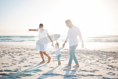 Image of Happy family, holding hands and playing on beach with mockup space for holiday weekend or vacation. Mother, father and child enjoying play time together on ocean coast for fun bonding in nature
