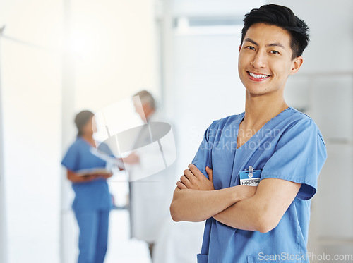 Image of Portrait, nurse and Asian man with arms crossed in hospital or clinic for healthcare. Face, confidence and happy medical professional, surgeon and doctor with pride for career, job and wellness.