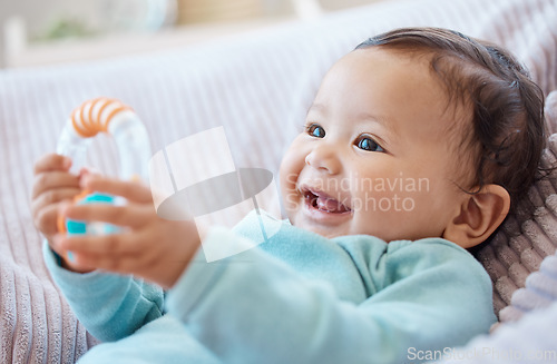 Image of Happy baby, rattle and child in bedroom for childhood development, growth and cute smile at home. Adorable young girl, infant kid and playing with toys for happiness, fun and relax in nursery room
