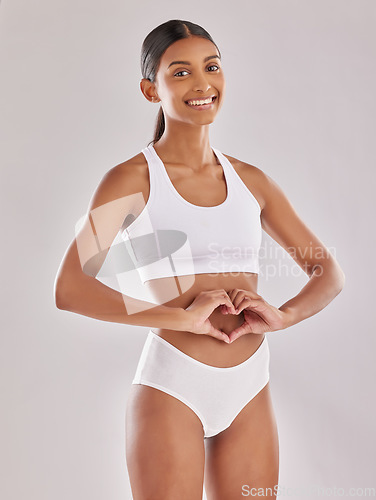 Image of Woman in underwear, portrait with heart hands and gut health, self love and fitness on studio background. Gesture, emoji and diet, healthy digestion and happy female model with body and lose weight