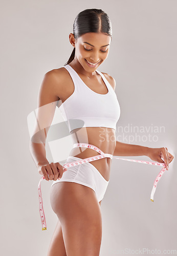 Image of Happy woman in underwear, body and measuring tape, lose weight and health with diet isolated on studio background. Healthy lifestyle, detox and liposuction, female person check progress of weightloss