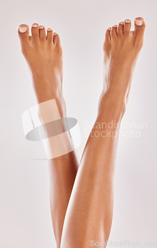 Image of Woman, legs and feet with beauty and skin, hair removal and pedicure isolated on studio background. Body, skincare and female model with dermatology and grooming, epilation and cosmetic treatment