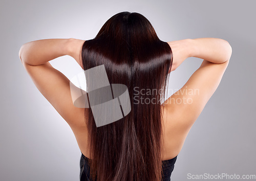 Image of Hair care, beauty and back of woman in a studio with a keratin, natural and salon treatment. Self care, health and female model with a long, shiny and brunette hairstyle isolated by a gray background