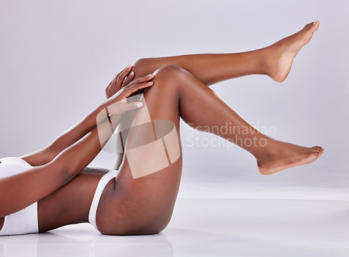 Image of Skincare, wellness and legs of woman on floor for shaving, grooming and hair removal in studio. Beauty, underwear and female person on white background for epilation cosmetics, natural skin or health