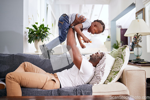 Image of Black family, airplane and father with son on a sofa with love, lifting and playing in their home together. Flying, child and fun with parent on sofa, laugh and play, bonding and games in living room