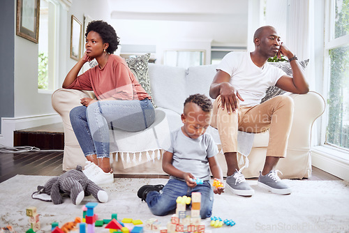 Image of Family, fight and couple argue on a sofa, stress and divorce with playing child on a living room floor. Marriage, crisis and angry woman with man on couch after conflict, argument or problem with son