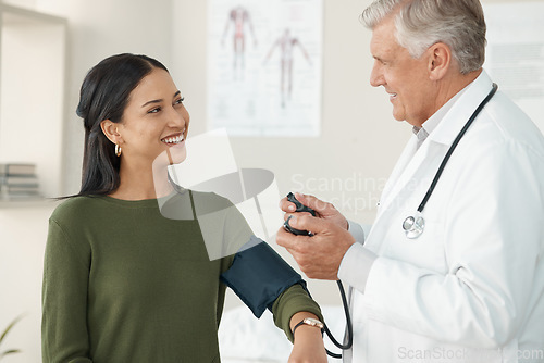 Image of Senior doctor, blood pressure or patient in a consultation, wellness or appointment with results, checkup or talking. Healthcare, woman or medical physician with cuff for hypertension or examination