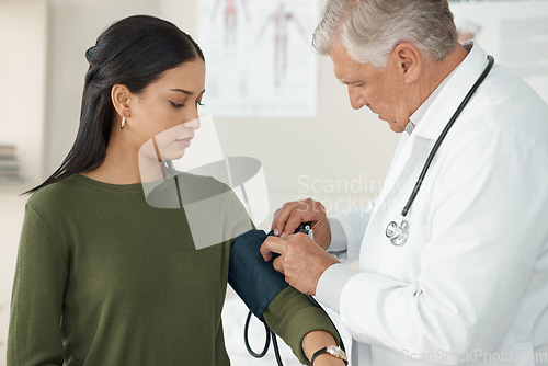 Image of Medical, blood pressure and mature doctor with a patient for a consultation in the hospital. Medicine, equipment and healthcare worker checking hypertension of a woman at a checkup in medicare clinic