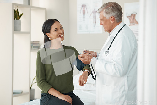 Image of Senior doctor, blood pressure and patient in a consultation, healthcare and appointment with treatment, diagnosis and results. Wellness check, woman or medical professional with cuff for hypertension