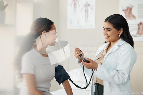 Image of Doctor, blood pressure and patient in a consultation, wellness checkup and appointment with diagnosis, talking and results. Healthcare, woman and medical physician with cuff for hypertension or test