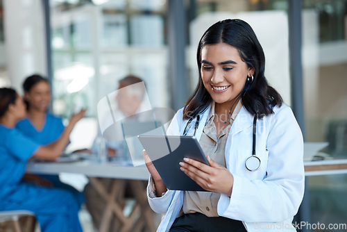 Image of Hospital, doctor and Indian woman on tablet for medical analysis, research and report in meeting. Healthcare, clinic and female nurse on digital tech for wellness app, online consulting and service