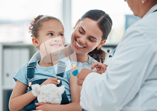 Image of Girl, mom and doctor with vaccine injection, cotton ball and flu shot on arm for disease or covid prevention in hospital. Woman, nurse and child with pediatrician help with bandaid, teddy or health