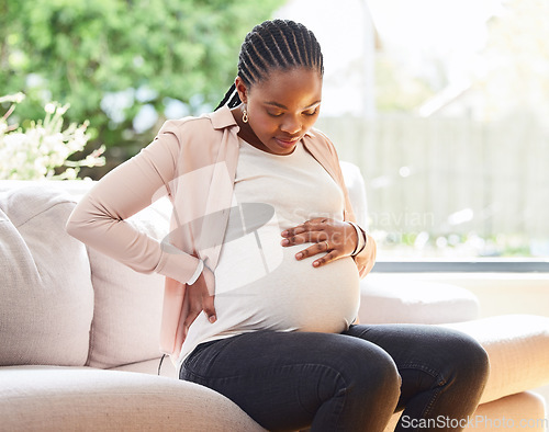 Image of Back pain, stomach and relax with pregnant woman on sofa for labor, healthcare and maternity. Ache, spine and emergency with African mother in living room of home for pregnancy and uncomfortable