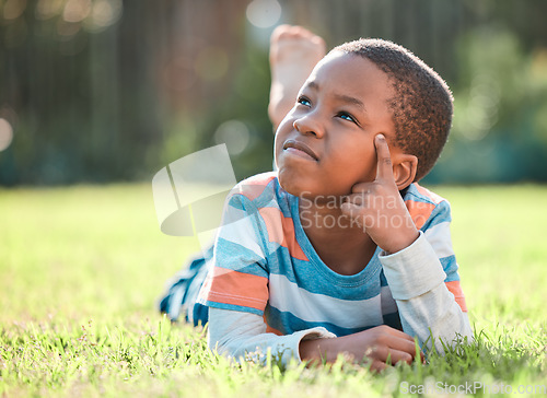 Image of Nature park, black boy thinking and lying on grass outside at park with a lens flare. Day dreaming or think, decisions and young male person on field with ideas or contemplating outdoors on lawn