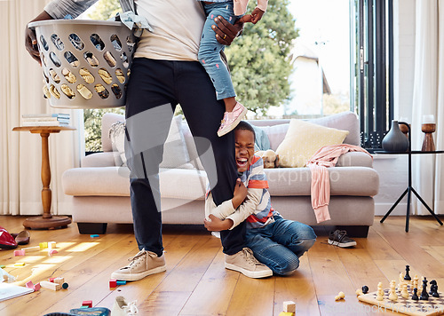 Image of Tantrum, crying and boy on leg of father shouting with anger, frustrated and upset emotions at home. Family, discipline and child holding parent scream with mess, laundry and toys in living room