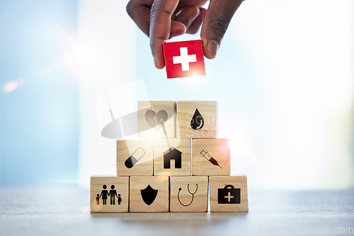Image of Hand, building blocks and man with cross, medical or icons for investment, security and insurance. Finger, choice and male with puzzle for healthcare, family or asset management, safety or planning