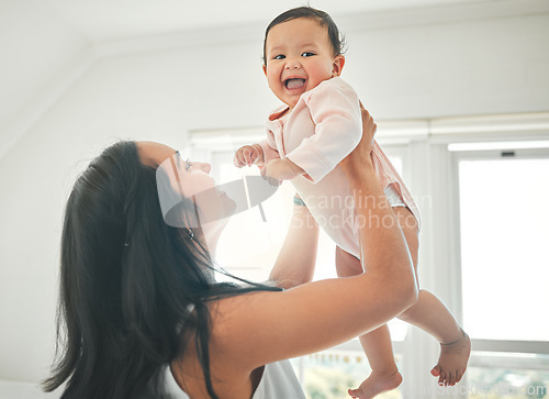 Image of Mother, lifting baby and happy in a family home with love, fun and quality time. Woman or mom and child relax and laugh together in a house for development, trust and support or care on mothers day