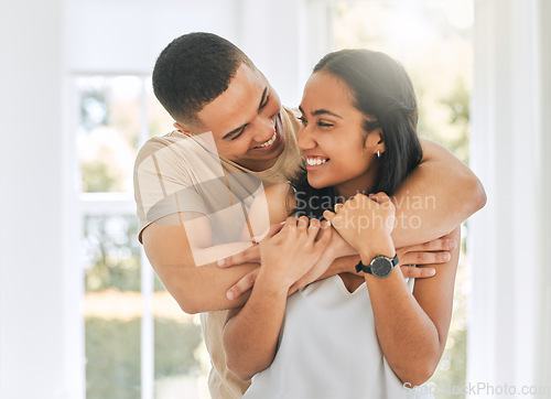 Image of Couple, hug and smile in home for love, care and relax for romance, support and trust of bond together. Happy man, woman and hugging partner for quality time, happiness and commitment to relationship