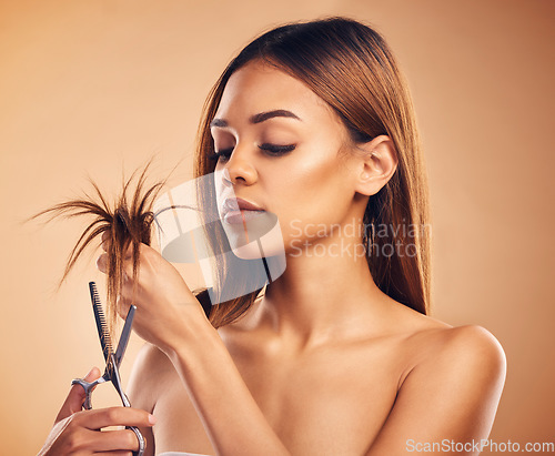 Image of Woman cutting hair, split ends and beauty with haircare, damage and dry texture isolated on studio background. Female model, scissors for tips and cosmetic keratin treatment, haircut and hairstyle