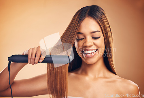 Image of Woman, hair and beauty, flat iron and smile, haircare and keratin treatment isolated on studio background. Female model with highlights, electric straightener and heat, happy with growth and texture