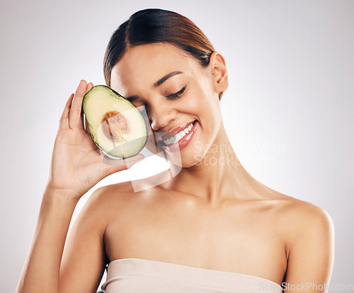 Image of Happy, skincare and woman with avocado in studio for natural, cosmetics or facial on grey background. Smile, glow and girl model with fruit for vegan, environmental or skin detox with collagen
