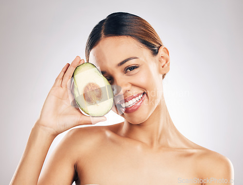 Image of Woman, skincare and avocado in studio portrait for health, wellness or facial glow by white background. Girl, model and healthy skin with fruit, makeup or cosmetics for self care, aesthetic and smile