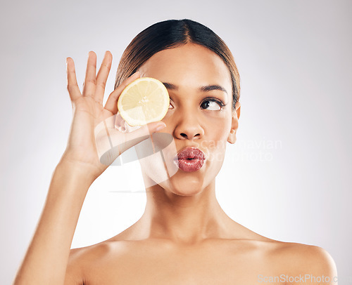 Image of Woman, kiss face and lemon with beauty, skincare with organic cosmetic product isolated on studio background. Natural cosmetics, female model with pout and citrus fruit for skin glow with dermatology