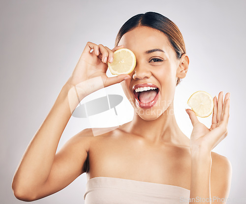 Image of Woman, lemon and studio portrait for skin health, wellness and facial glow by white background. Girl, model and healthy skincare with youth, makeup and cosmetics for self care, funny face and excited