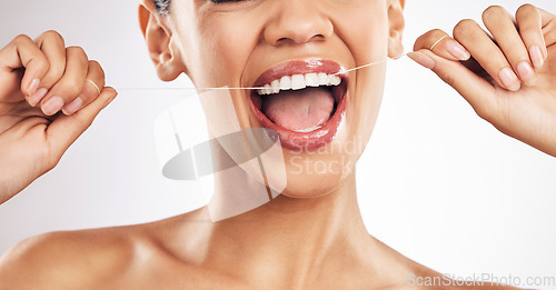 Image of Smile, dental and woman flossing teeth in studio for hygiene, wellness or fresh breath on grey background. Hands, floss and lady relax with mouth, tooth or cleaning for oral care or cavity prevention