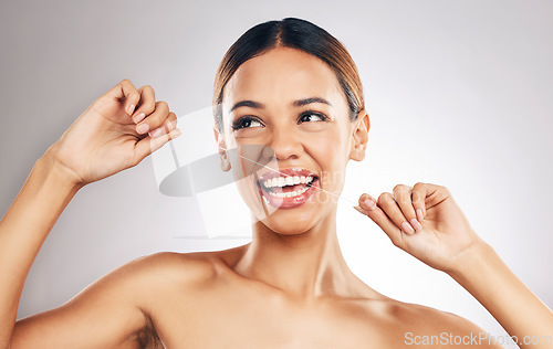 Image of Smile, dental floss and woman in studio for mouth, teeth and wellness, hygiene or fresh breath on grey background. Flossing, happy and girl model cleaning gum, tooth and bacteria or cavity prevention