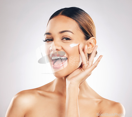 Image of Happy woman, cream on face and beauty with skincare, smile and moisturizer isolated on studio background. Excited female model apply lotion, dermatology and cosmetic product with skin glow and facial