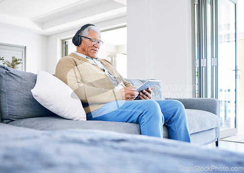 Image of Elderly man, relax with tablet and headphones at home, retirement and technology with online streaming. Surfing internet, watching videos and wireless tech with old male person sitting on couch