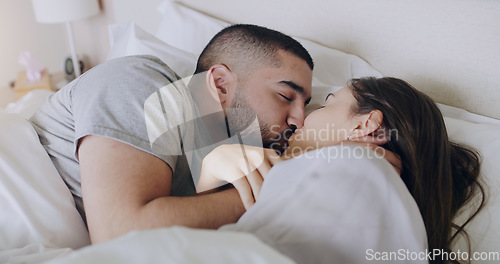 Image of Couple, kiss and bedroom for love, care and romance of intimacy, special moment and quality time together at home. Man, woman and kissing partner for relationship, honeymoon and relax in the morning