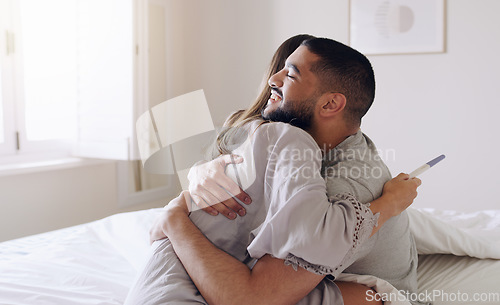 Image of Couple, hug and happy for pregnancy test in bedroom, home and support to celebrate good news. Excited man, woman and partner hugging in celebration of pregnant results, future family or ivf fertility