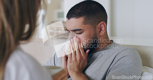 Image of Blowing nose, sick and care with couple in bedroom for sickness, healthcare and illness. Virus, fatigue and worry with man and woman in bed at home for sneeze, fever and wellbeing treatment