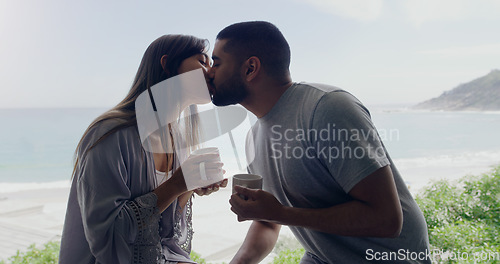 Image of Couple, kiss and coffee in morning on balcony with love, romance and care on holiday by ocean with sunshine. Man, woman and trust with drink, espresso or matcha on vacation by sea with bond in summer