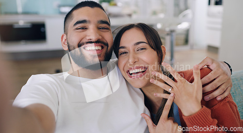 Image of Couple, selfie and engagement ring in living room portrait for happiness, romance and love on social media app. Man, woman and excited for marriage proposal, offer and celebration with smile on blog