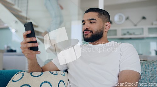 Image of Man, cellphone and typing on sofa in living room, reading social media post and online blog. Young male person, relax and texting on smartphone, download mobile games and website connection at home