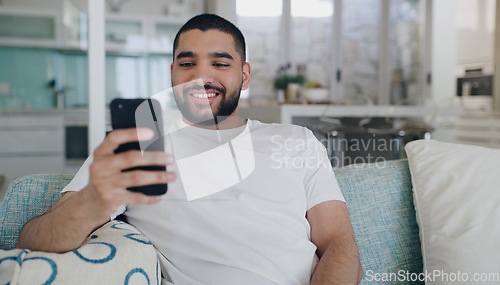 Image of Happy, man and typing on smartphone in living room, reading social media post and online blog. Young male person, smile and relax with cellphone, download mobile games and website connection at home