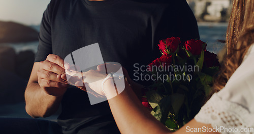 Image of Love, proposal and engagement with hands of couple in outdoor for marriage, commitment or trust. Wedding ring, roses and jewelry with closeup of man and woman for announcement, celebration and fiance