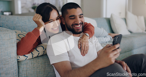 Image of Couple, phone and laughing at meme on social media or internet joke and relax in a living room couch in a home. Sofa, cellphone and people streaming online comedy on a smartphone in a house together